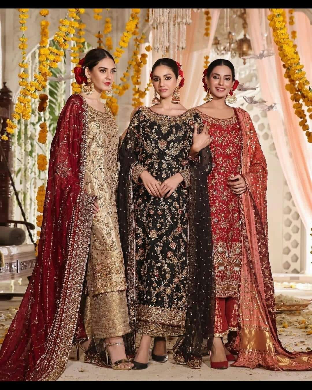 Three beautiful models wearing black, maroon and golden heavy embroidery Punjabi party wear suits by Veeriva