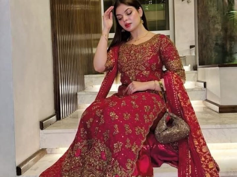 Beautiful woman wearing a magenta pink Punjabi suit with heavy embroidery party wear design