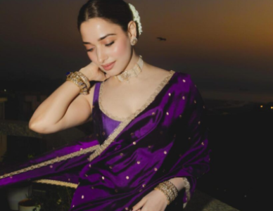 Beautiful woman wearing a sleeveless blouse with a purple party wear saree showcasing premium ethnic fashion